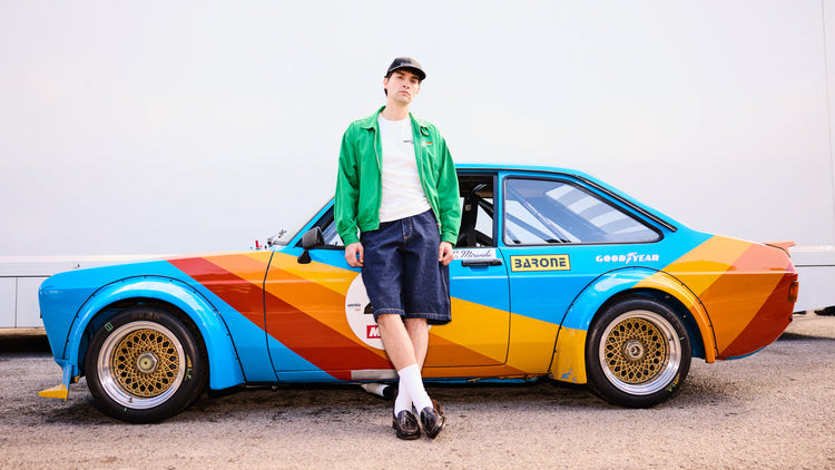 Male model wearing Chequerboard Festival of Speed Hoody in Blue sitting down