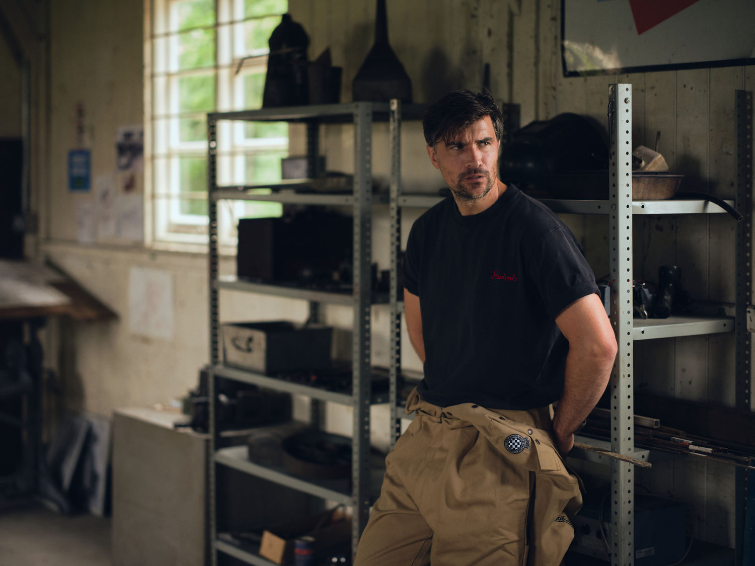 Model wearing Revival Embroidered T-shirt leaning in garage