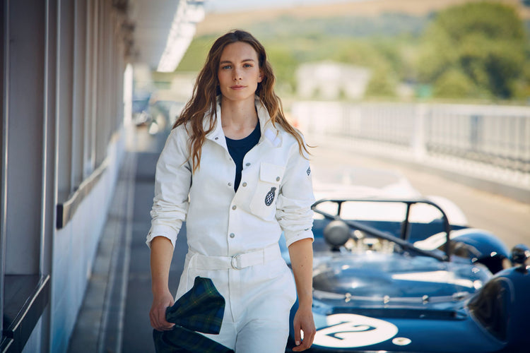 Female model wearing white overalls at Goodwood Motor Circuit carrying Freddie March silk scarf.