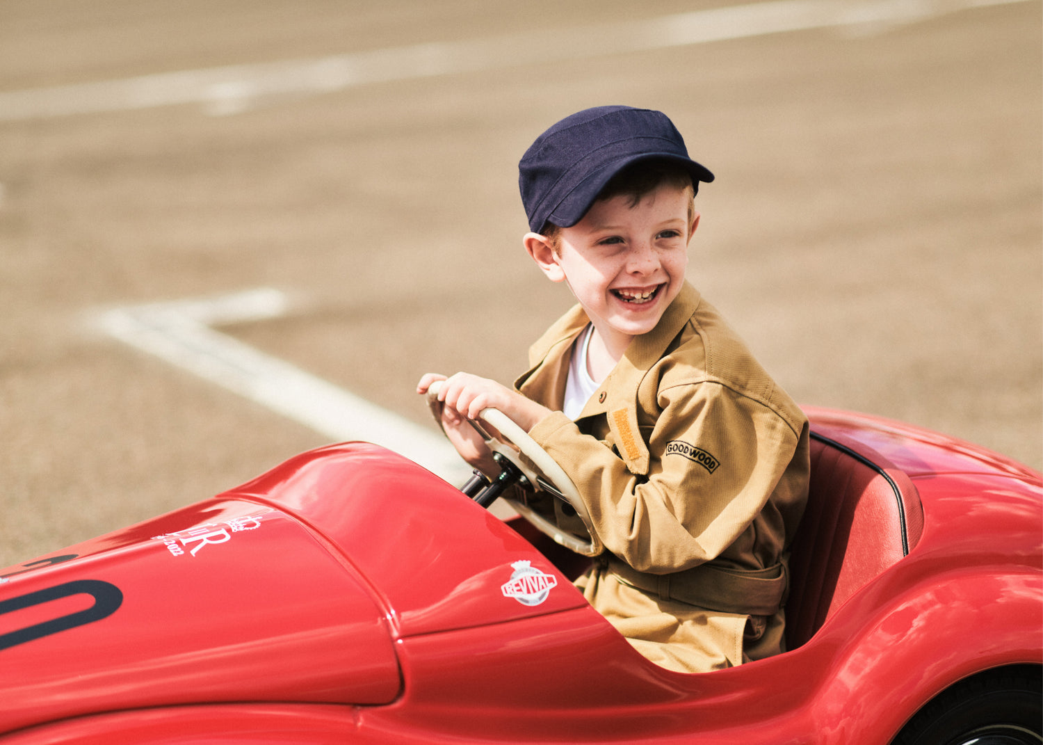 Boy wearing Goodwood Children's overalls in Khaki in red Austin J40