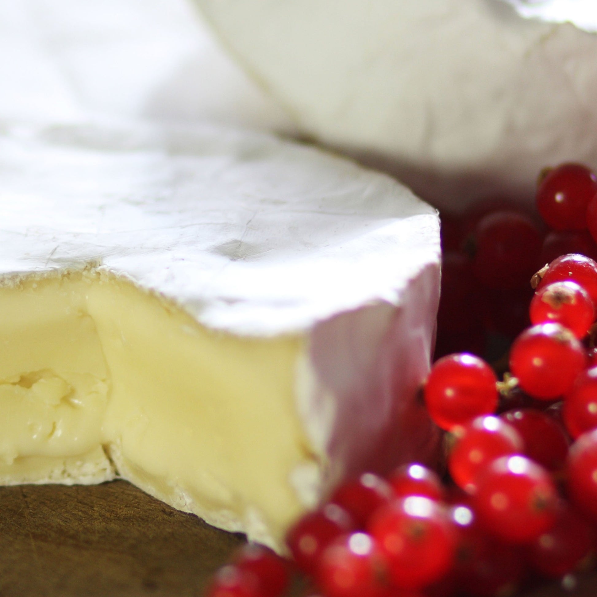 Goodwood's rich and creamy Levin Down soft white cheese, displayed on a cheese board with red berries.