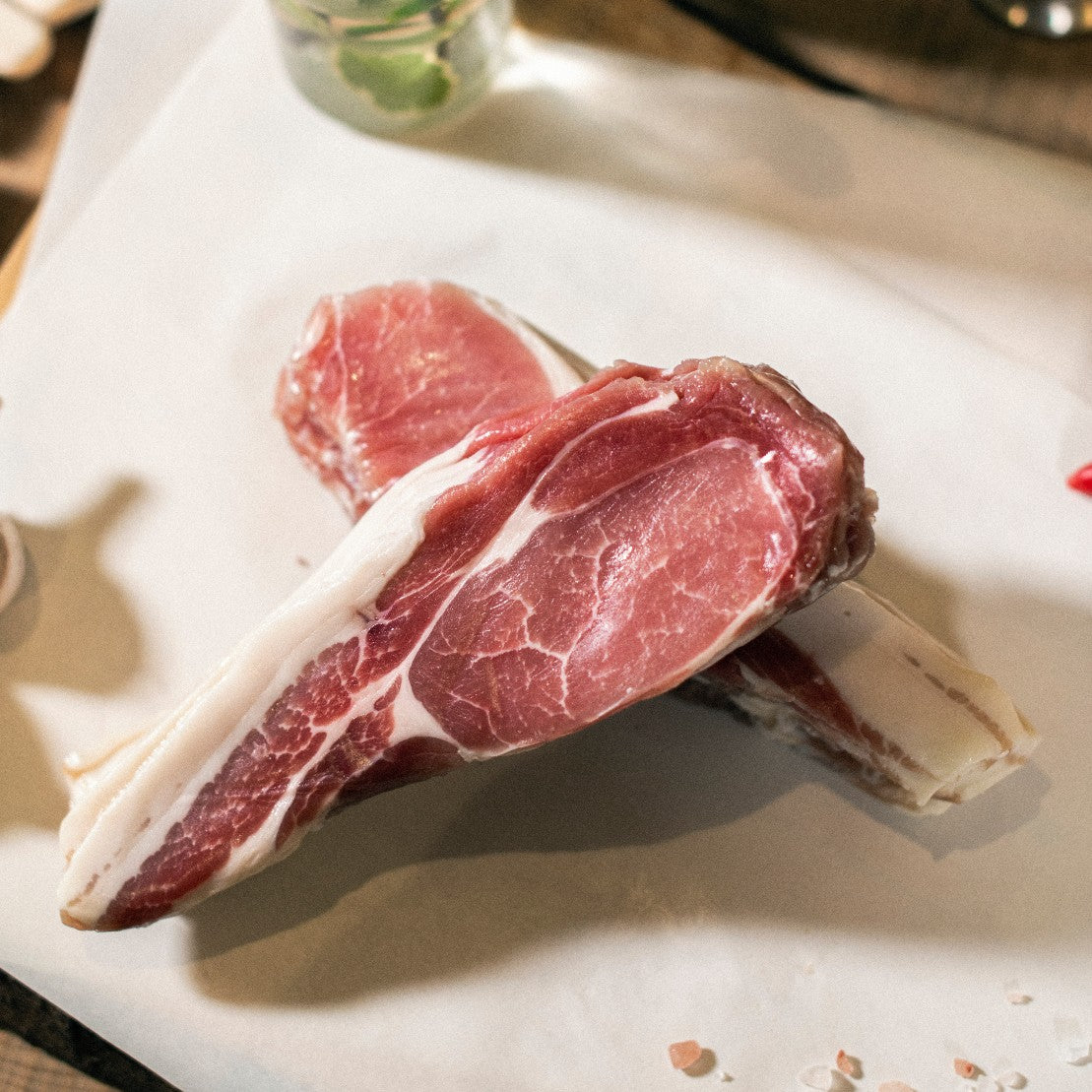 A close up of two stacks of organic grass-fed pork back bacon rashers.