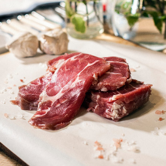 Goodwood organic pork collar bacon rashers, displayed on a chopping board at Goodwood Farm Shop.