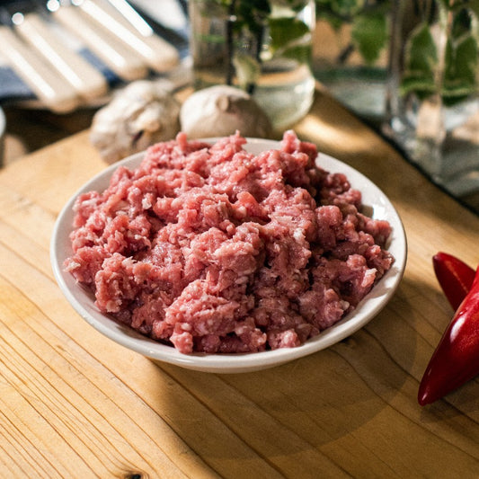 A bowl of organic West Sussex grass-fed pork mince, shown on a chopping board at Goodwood Farm Shop.