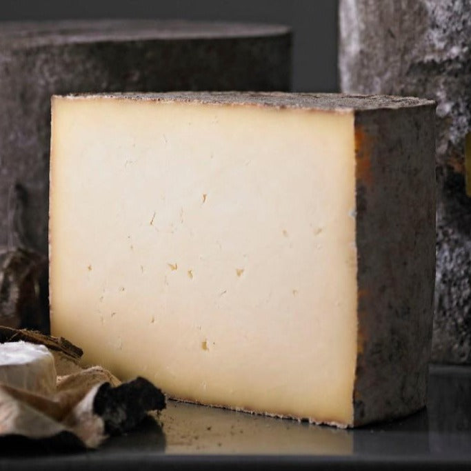 Goodwood's Charlton farmhouse cheese ready to be sliced for a cheese board, available at Goodwood Farm Shop.