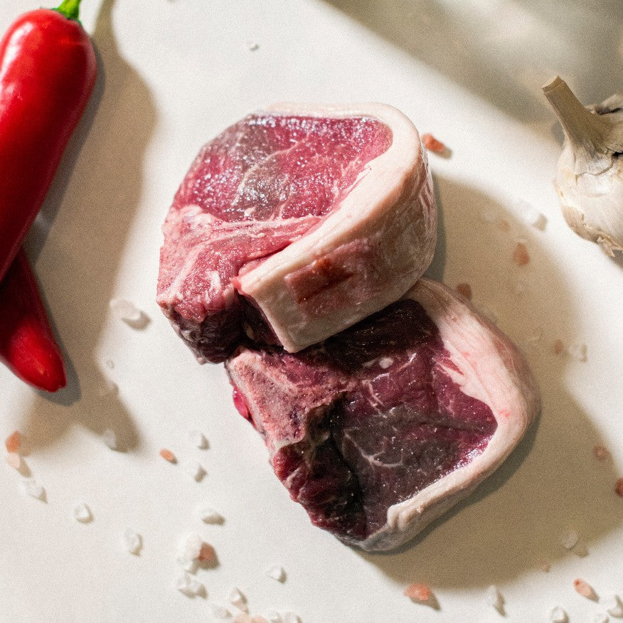 A close up of a pair of organic grass-fed lamb loin chops available at Goodwood Farm Shop.