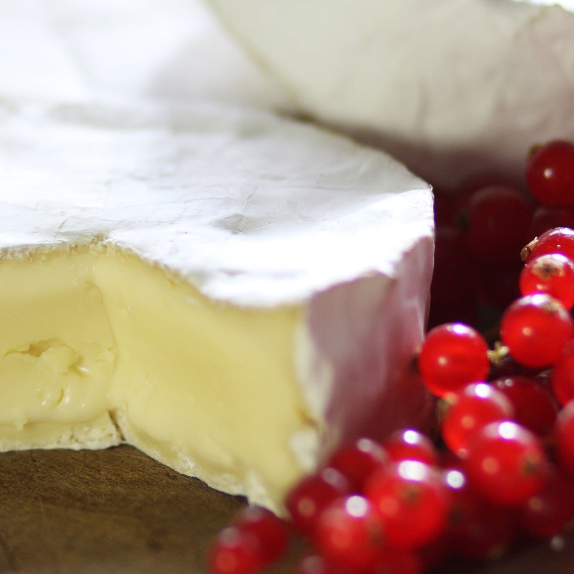 Goodwood's rich and creamy Levin Down soft white cheese, displayed on a cheese board with red berries.