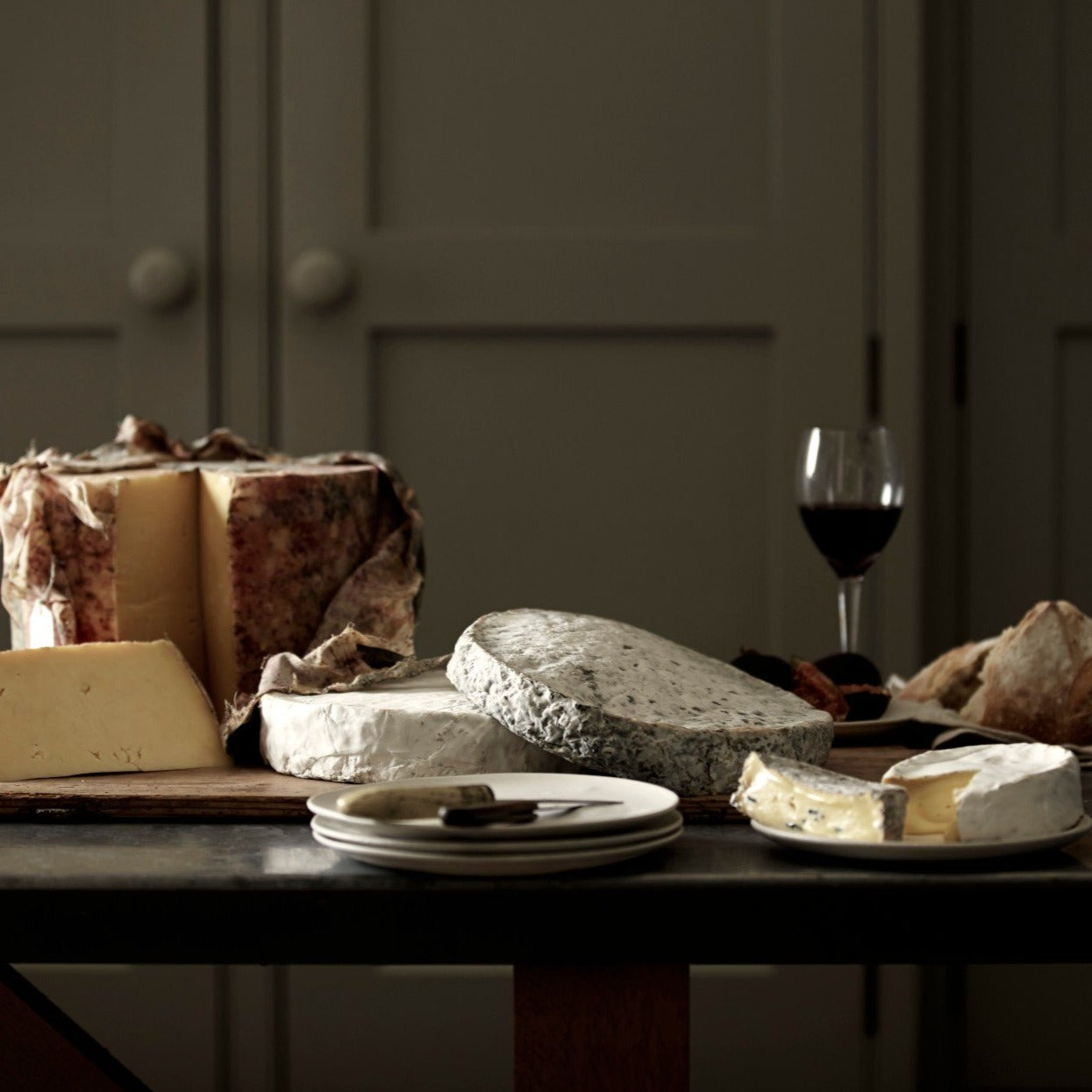 A cheese board selection of handmade Goodwood Farm Shop cheeses, displayed on a table.