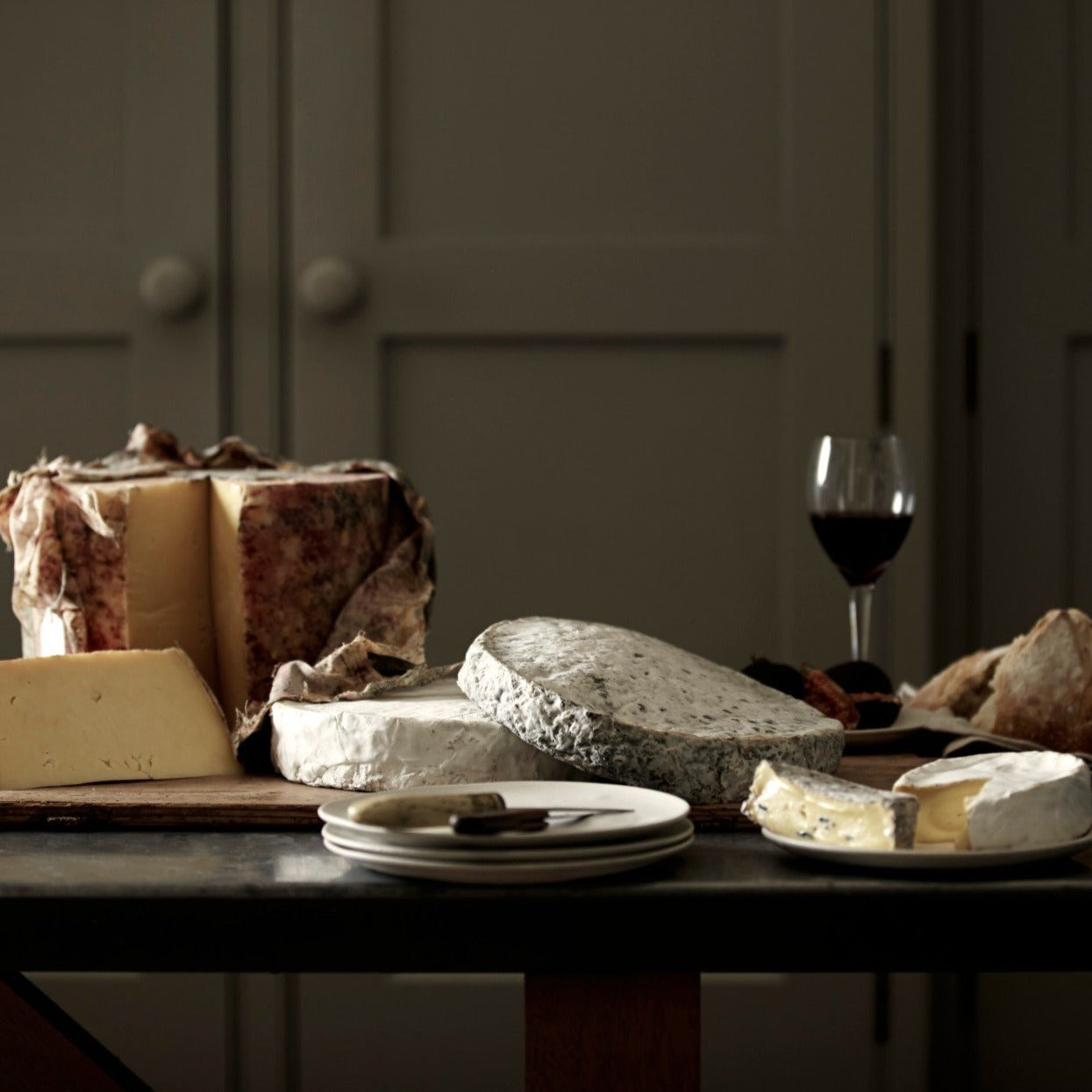 A cheese board selection of handmade Goodwood Farm Shop cheeses, displayed on a table.